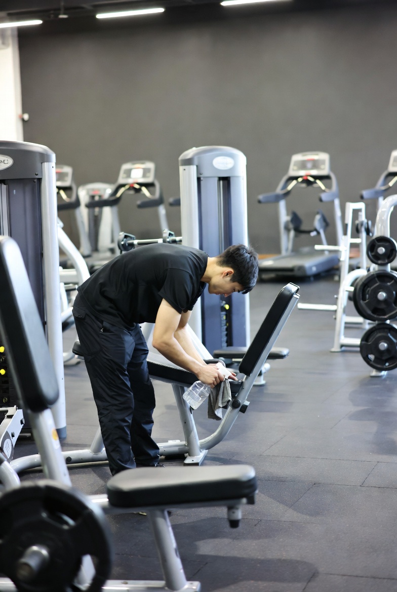 osoba sprzątająca na sali fitness/siłowni
